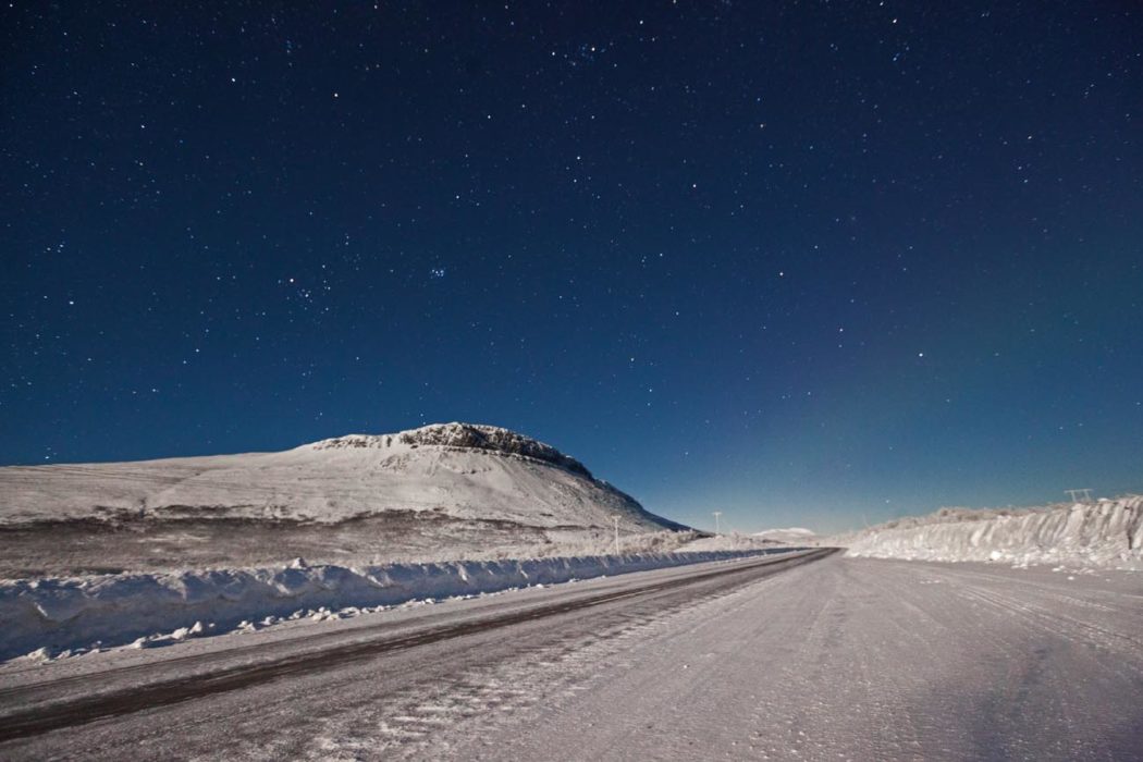 Paisagem de inverno em kiruna na Suécia com neve e estrada mais Aurora Boreal