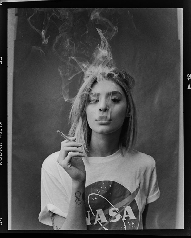 Modelo fumando em foto preto e branco com fumaça do cigarro Gabi Lisboa bordas do filme negativo