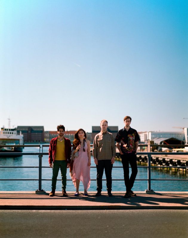 Banda musical de quatro integrantes em cima de ponte