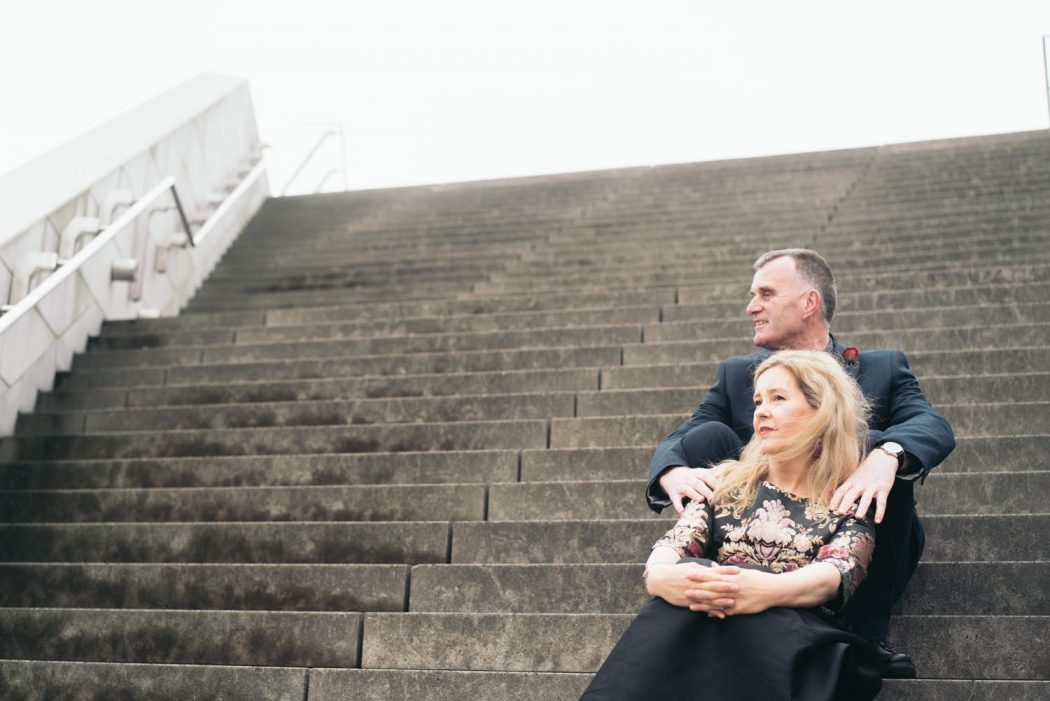 Casal de meia idade ensaio fotográfico em paisagem clássica sentados em escada