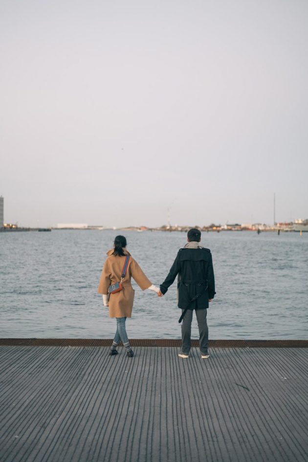 Casal de mãos dadas de frente para o mar em Copenhagen na Dinamarca