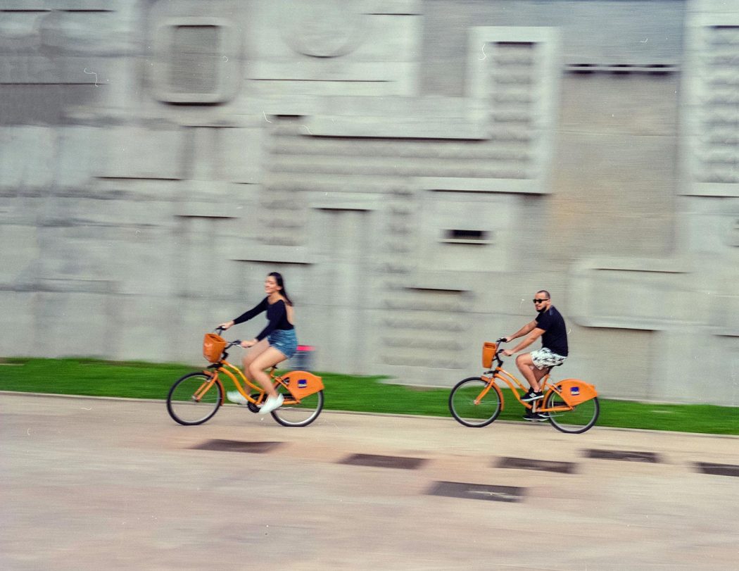 Ensaio casal urbano em Belo Horizonte andando de bike itau na praça