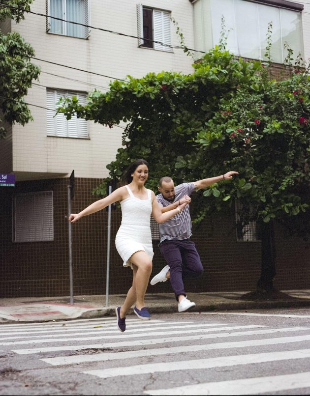 Ensaio casal urbano em Belo Horizonte saltando no ar sobre faixa de pedestres