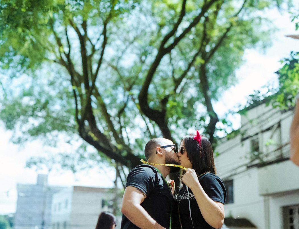 Ensaio casal urbano em Belo Horizonte em pé no bloco de carnaval com serpentina