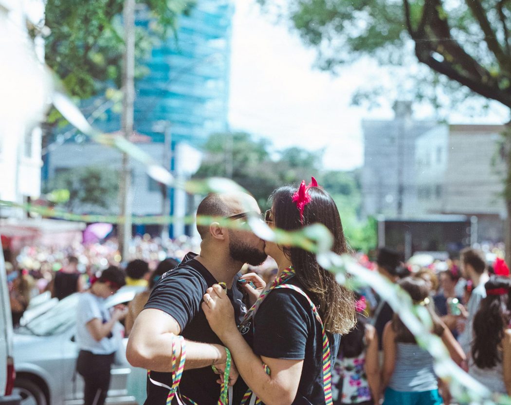 Ensaio casal urbano em Belo Horizonte em pé no bloco de carnaval com serpentina